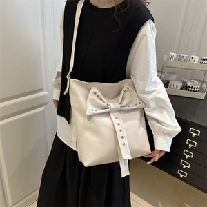 Fashionable cream white crossbody bag featuring stylish rivet details and a large bow design