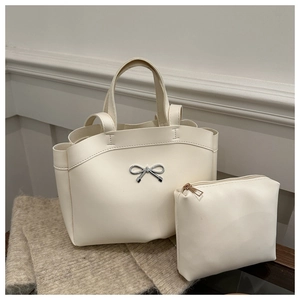 Detailed set of cream white leather bucket bag and matching zipper pouch with silver bow
