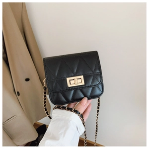 Detail of black quilted leather crossbody bag with a gold rectangular twist lock