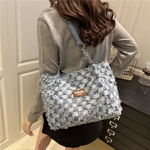 Retro blue and white checkered denim tote bag with frayed edges and long leather shoulder strap