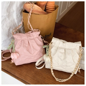 Close-up of pink and cream quilted bucket bags with chain straps and tulip charms