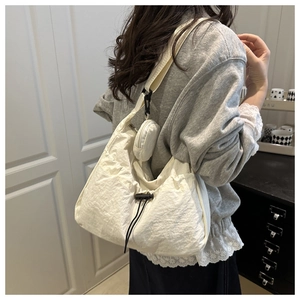 Detail of off-white nylon hobo bag with drawstring and matching round coin purse pouch