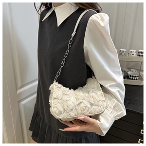 Detail of elegant white 3D fabric flower petals on a chic women handbag with chain