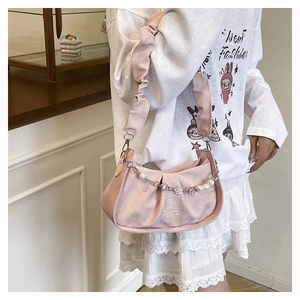 Detail of pink pleated shoulder bag with pearl clover chain and ruffle strap