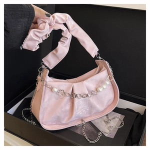 Détail du sac à bandoulière plissé rose avec chaîne de perles et poignée à volants