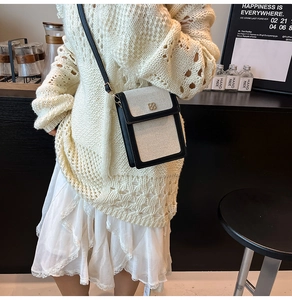 Détail du sac de téléphone en toile avec bordure en cuir et boucle dorée sur un mannequin