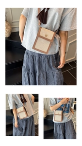 Détail du mini sac seau en toile avec garniture en cuir et fermoir trèfle doré