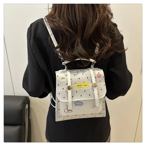 Detail of grey polka dot mini backpack with lace trim and cute cartoon patches