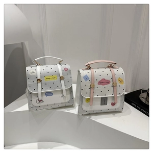 Detail of polka dot handbags with cartoon patches and decorative belt straps