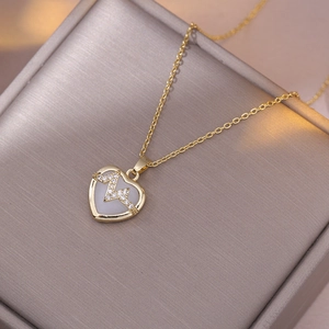 Collier électrocardiogramme doré avec pendentif cœur en opale et strass sur boîte grise