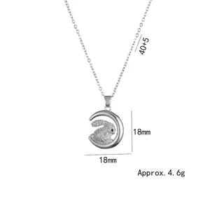 Close-up of silver crescent moon and crystal-studded rabbit pendant necklace detail