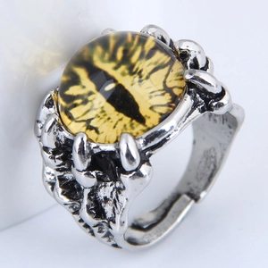 Macro shot of silver dragon claw ring holding a detailed yellow evil eye glass bead