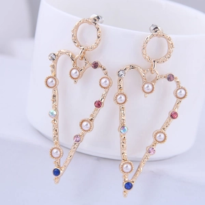 Detail of hollow heart earrings with colorful rhinestones and white pearls on gold base