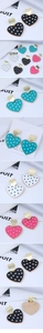 Détail de boucles d'oreilles cœur à pois blancs avec clous en finition dorée