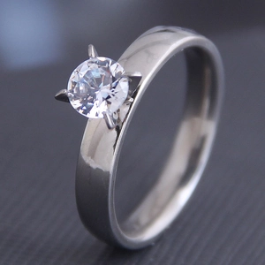 Detailed side view of silver steel ring with round cubic zirconia in four-prong setting
