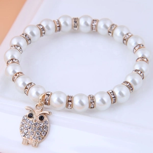 Beaded pearl bracelet with a sparkling gold owl charm and crystal accents for women