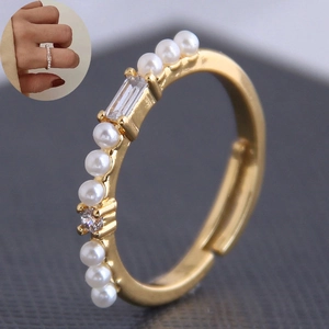 Détail de la bague dorée ajustable ornée de perles blanches et d'oxydes de zirconium