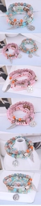 Detail of bohemian multilayer beaded bracelets with Eiffel Tower and wing charms