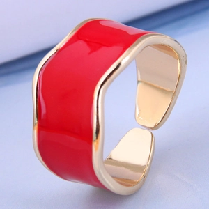 Macro shot of gold-plated wide open ring with vibrant red enamel and wavy edges