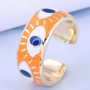 Détail macro de la bague œil maléfique plaquée or avec émail orange et bleu éclatant