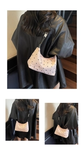 Detail of light pink quilted hobo bag with black bow embroidery and silver buckle