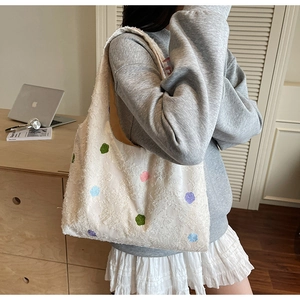 Détail du motif à pois colorés et du tissu en peluche doux du sac à bandoulière pour femme