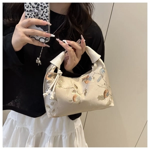 Detail of champagne jacquard fabric shoulder bag with floral embroidery and beaded drawstring