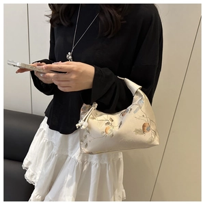 Detail of beaded handle and embroidered bird pattern on beige Chinese style canvas bag
