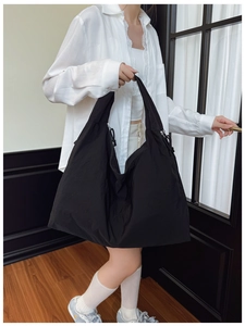 Détail d'un grand sac fourre-tout noir en nylon avec cordon de serrage et tissu léger