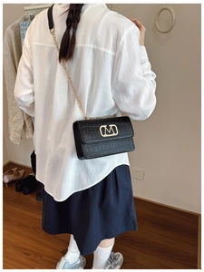 Bolso bandolera negro con estampado de cocodrilo moderno y detalle de cadena dorada