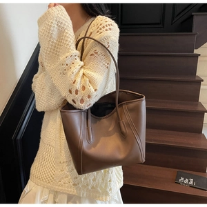 Macro shot of brown leather tote bag with embossed logo and elegant matte finish