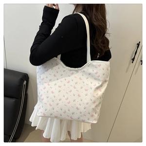 Detail of floral canvas tote bag with pink butterfly prints worn over the shoulder