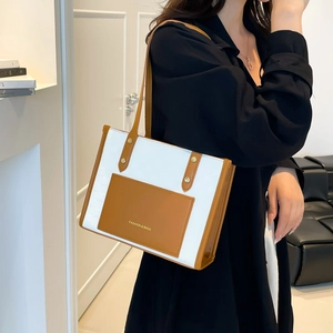 Women's two-tone white and brown leather tote bag with shoulder straps and front pocket