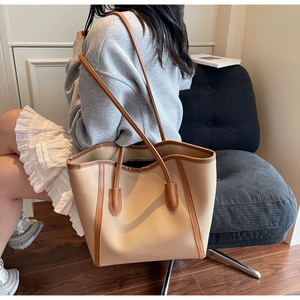 Detail of beige tote bag with brown leather trim and Fashion & Bags printed text