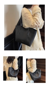 Detail of minimalist black leather tote bag with gold logo and slim shoulder straps