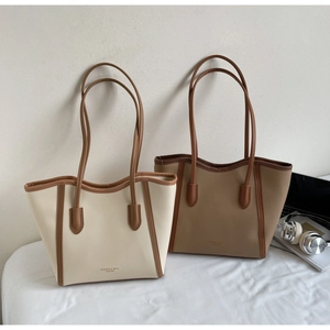 Comparison of beige and khaki tote bags with leather texture and minimalist logo design
