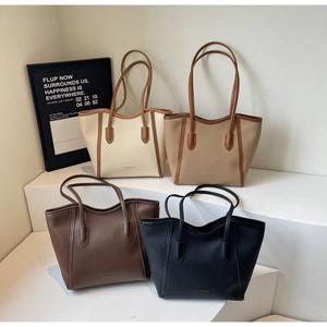Four colors of large leather tote bags shown on stairs in cream, khaki, brown, and black