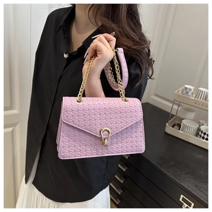 Détail du sac carré rose clair tissé avec un fermoir doré et une bandoulière