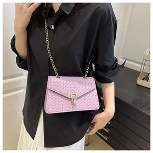 Détail d'un sac bandoulière tissé violet clair avec fermoir rotatif en fer à cheval doré
