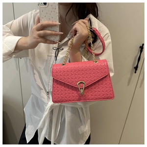 Sac rose tressé avec chaîne et boucle dorée présenté dans un selfie miroir style