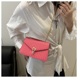 Détail du sac bandoulière tressé fuchsia avec boucle en U dorée et bandoulière