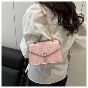 Détail du sac bandoulière rose tissé avec rabat texturé et boucle dorée en forme de U