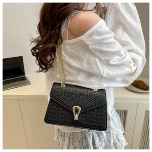 Détail du sac en cuir gaufré noir avec fermoir fer à cheval doré et chaîne métal