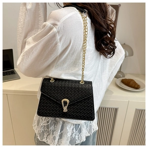 Détail d'un sac à bandoulière en cuir PU noir motif crocodile avec chaîne dorée