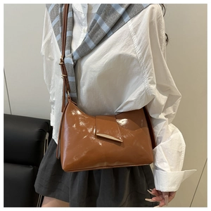 Détail du sac d'épaule en cuir verni marron avec boucle magnétique métallique chic
