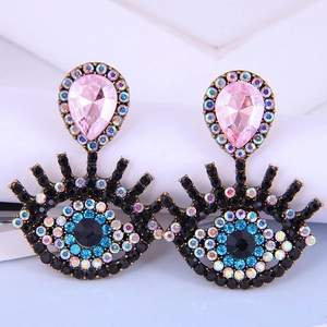 Dettaglio di orecchini occhio del diavolo con cristallo rosa e strass luccicanti