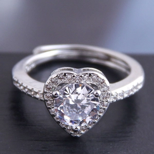 Macro shot of a heart-shaped zircon ring featuring a micro-paved halo and adjustable silver band