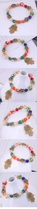 Dettaglio di perline di cristallo colorate e ciondoli Mano di Fatima su un bracciale elastico