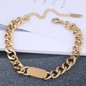 Macro detail of gold-plated stainless steel curb chain bracelet with blank metal plate