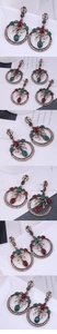 Macro detail of vintage bronze earrings featuring red and green gems with crystal inlay